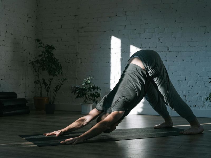 Person practicing a focused yoga pose in a calm, minimalist environment.